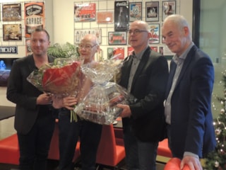 Cultuurwethouder Samir Bashara (l) en Hans Stuijfbergen en Wim van de Water feliciteren Han Hensen als mijoenste bezoeker